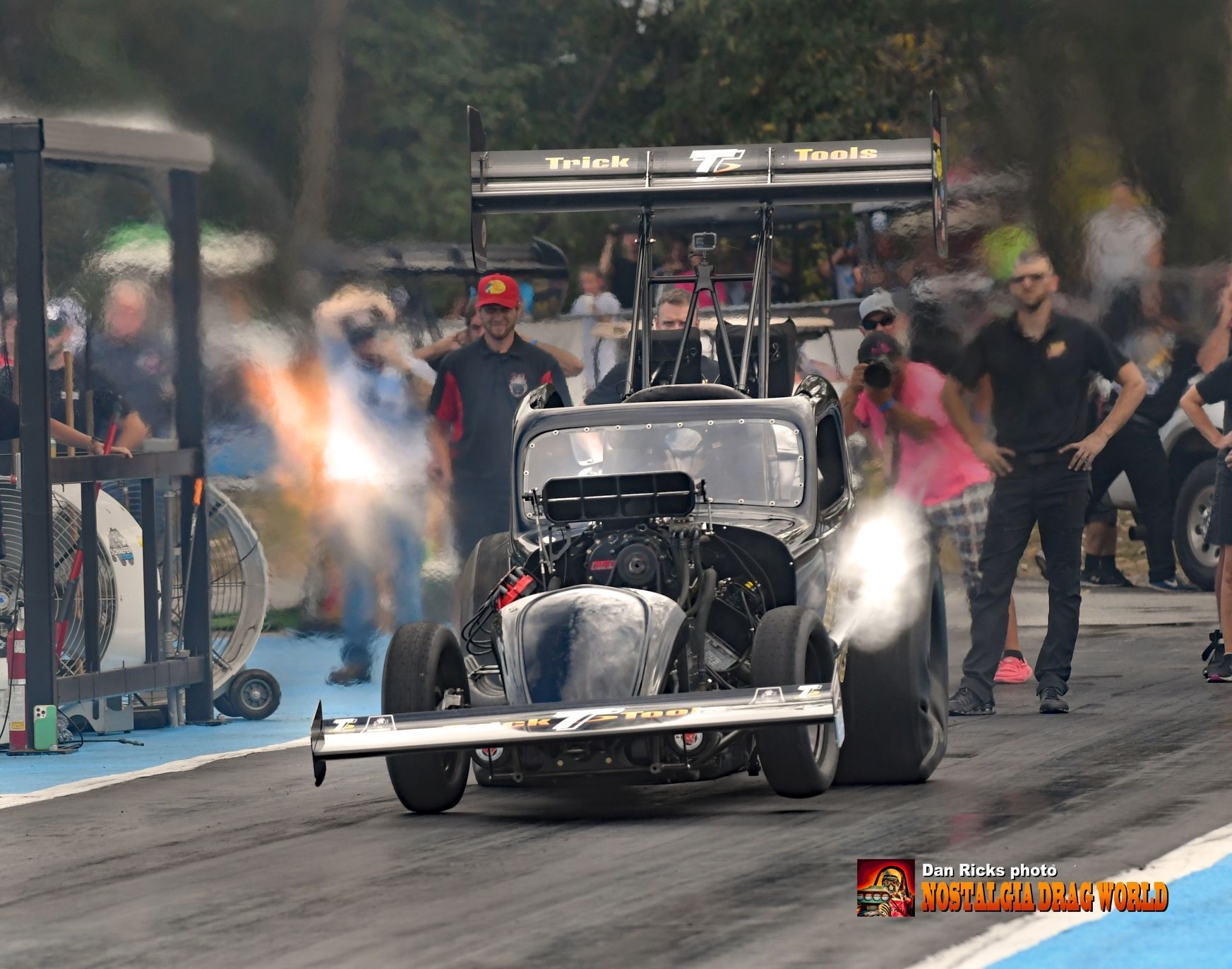 A race car is on a track with people watching