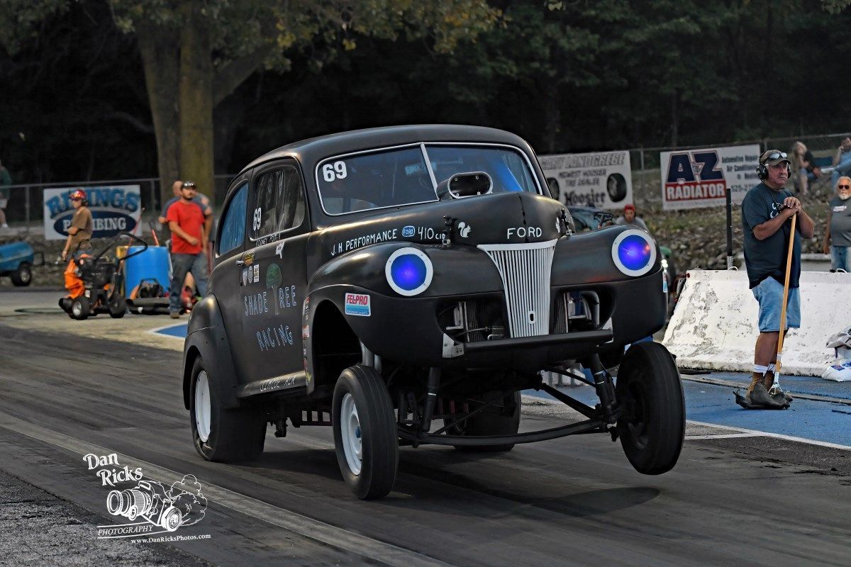 A black car with blue lights is driving down a race track.