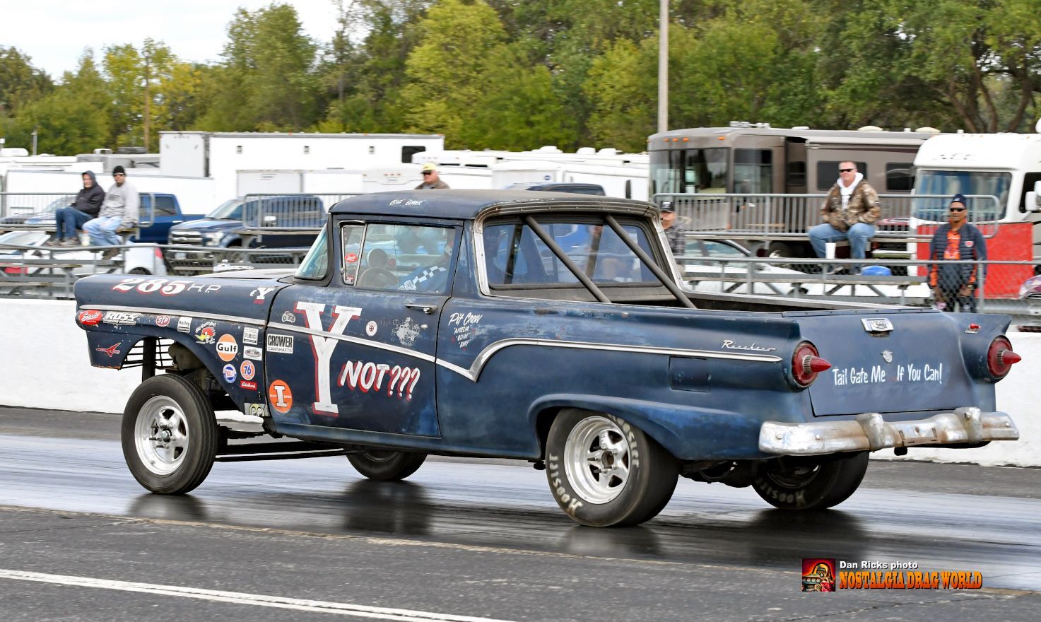 A blue truck with the word north on the back is parked on the side of the road.