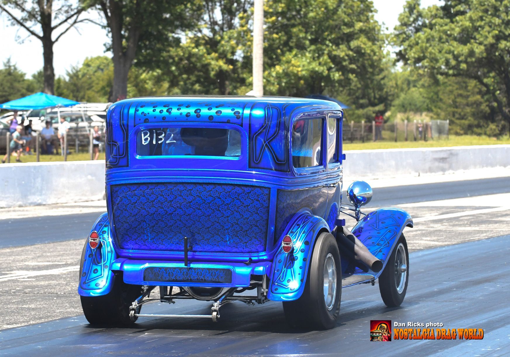 A blue car with the number 813 on the back