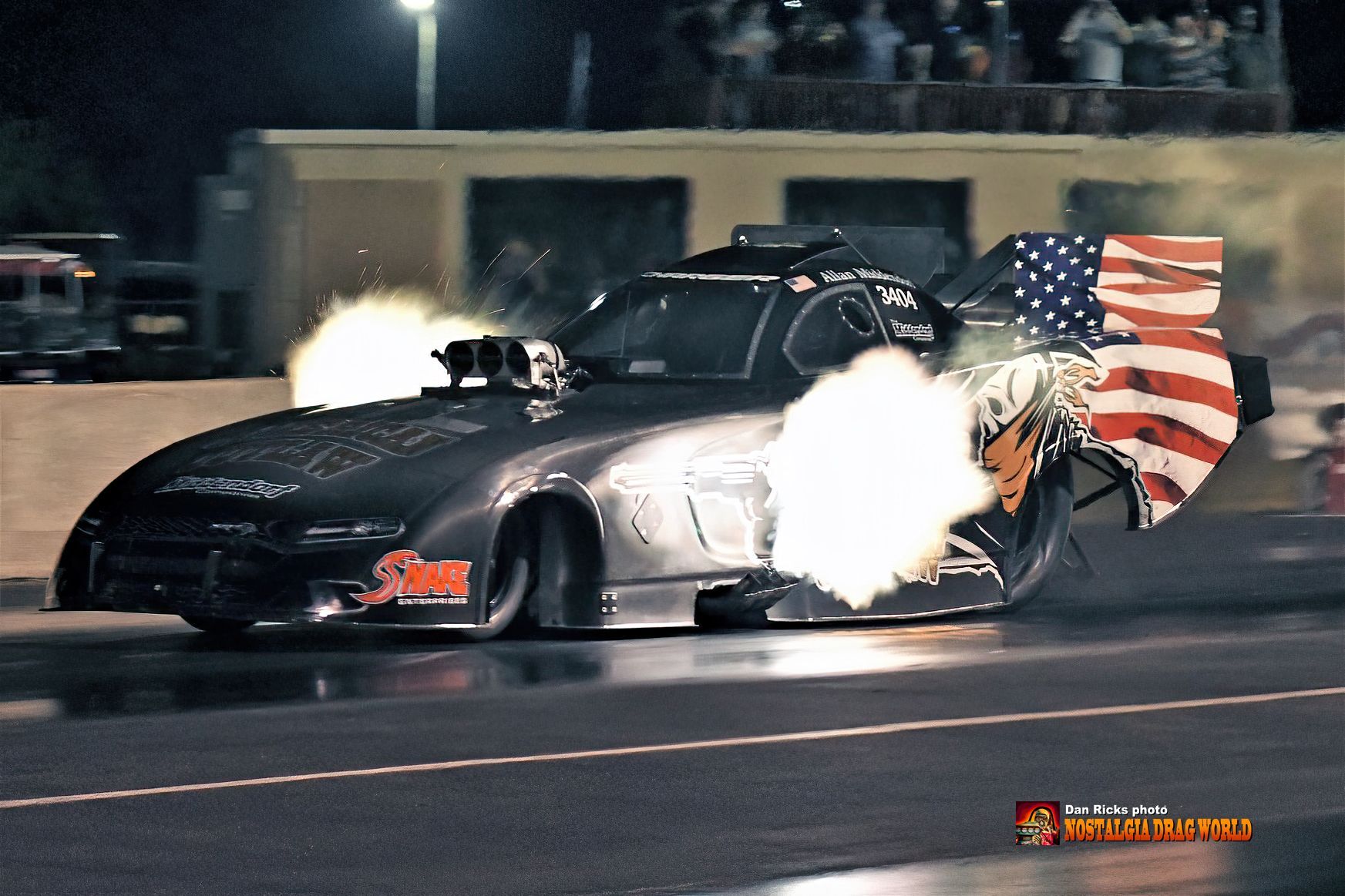 A race car with an american flag on its wing