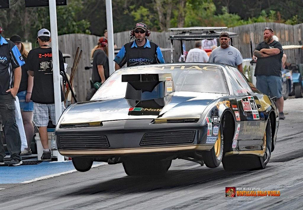 A race car is driving down a track with people watching