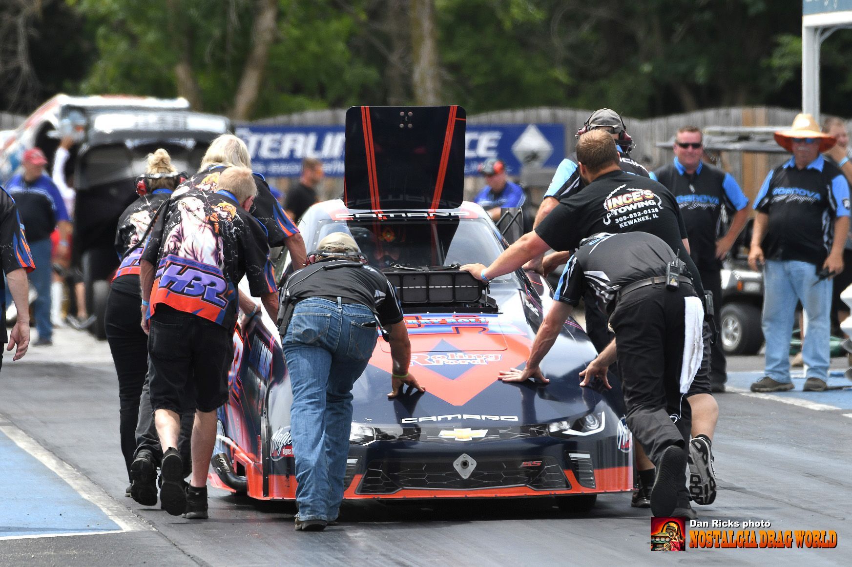 A group of people pushing a race car on a track