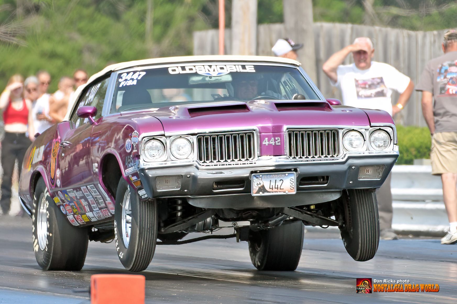 A purple oldsmobile 442 is on a race track