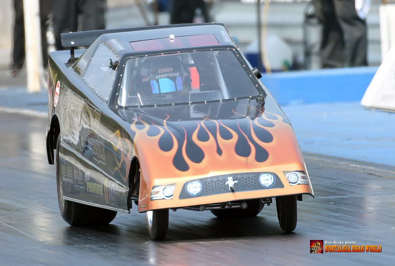 A car with flames on the front is driving down a track