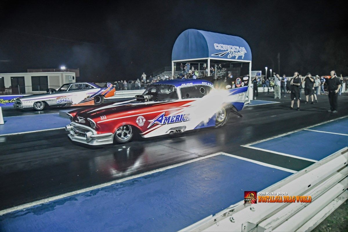 A red white and blue car is on a race track