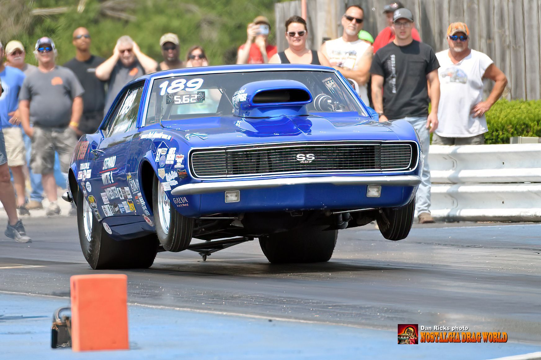 A blue car with the number 199 on the side is driving down a race track.
