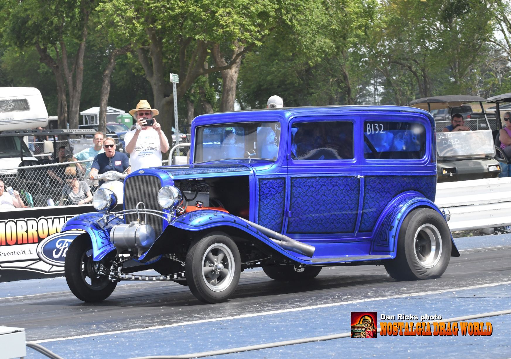 A blue car is parked in a parking lot with a sign that says monroe