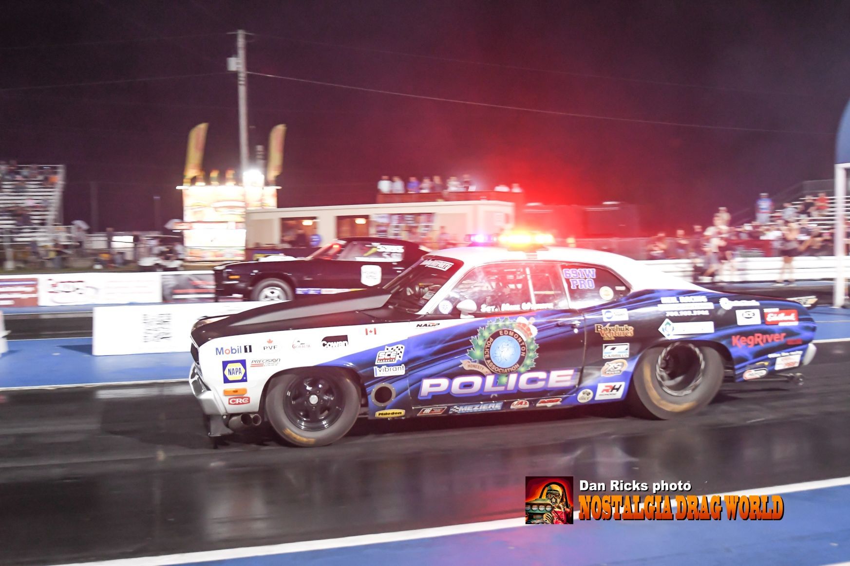 A police car is on a race track at night
