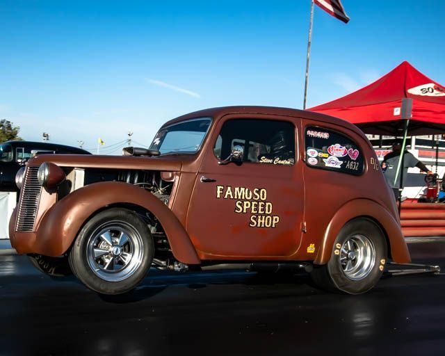 A brown car that says famous speed shop on the side