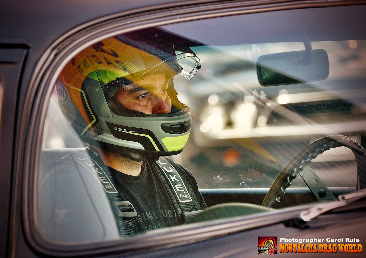 A man wearing a helmet is sitting in a car.
