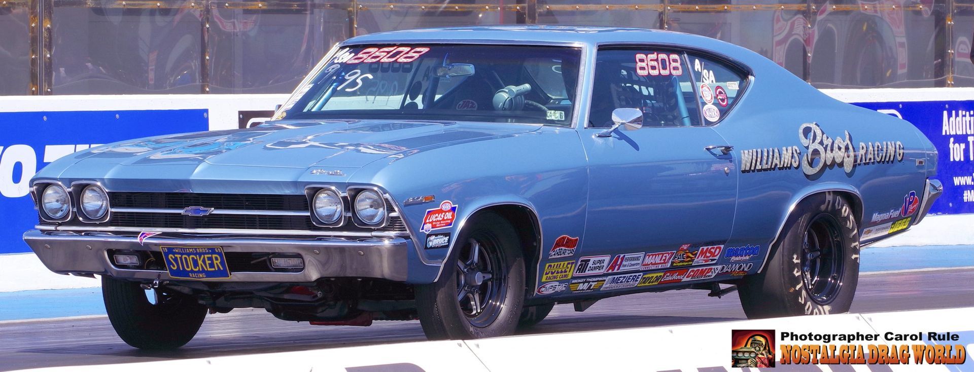 A blue car with a sticker on the windshield that says peter