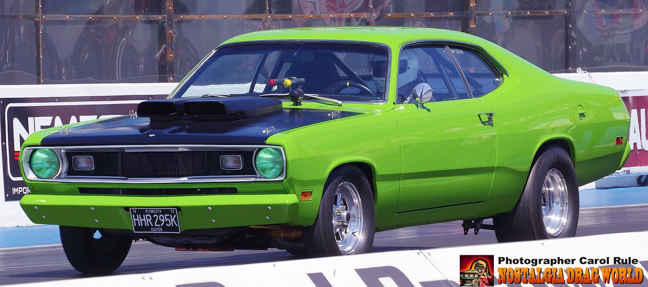 A green and black car is on a race track