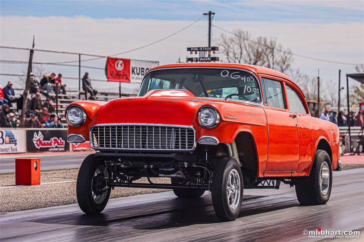 A red car is driving down a race track.