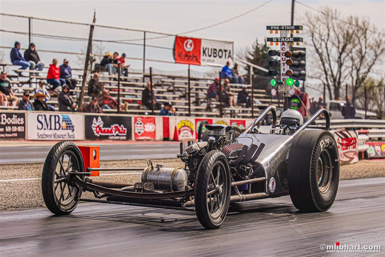 A racing car is driving down a race track.