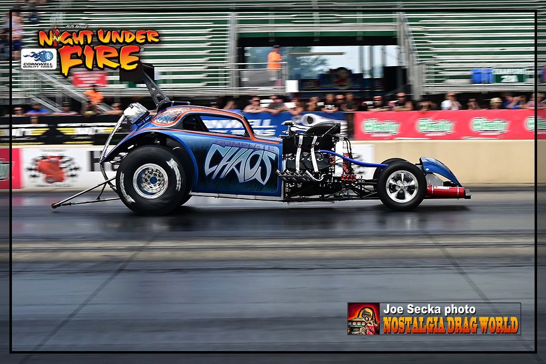 A blue racing car is driving down a race track.