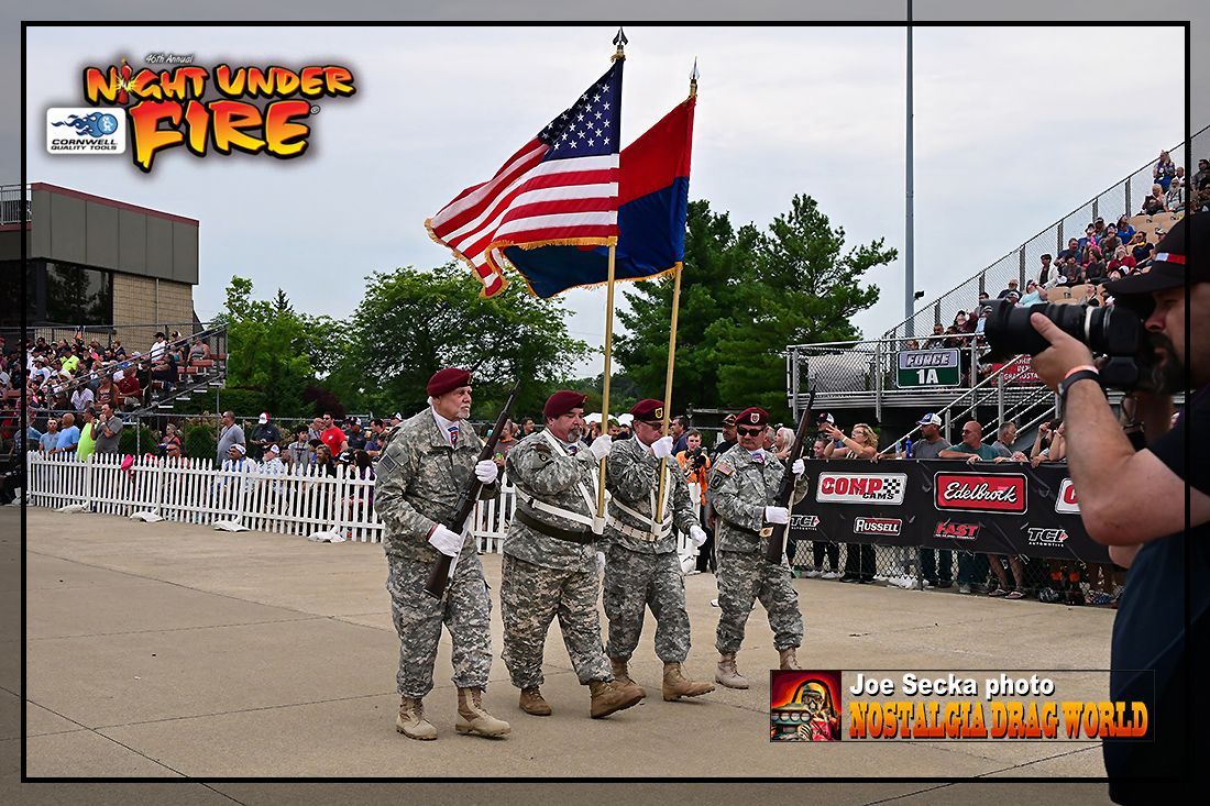 A man is taking a picture of a group of soldiers holding flags.