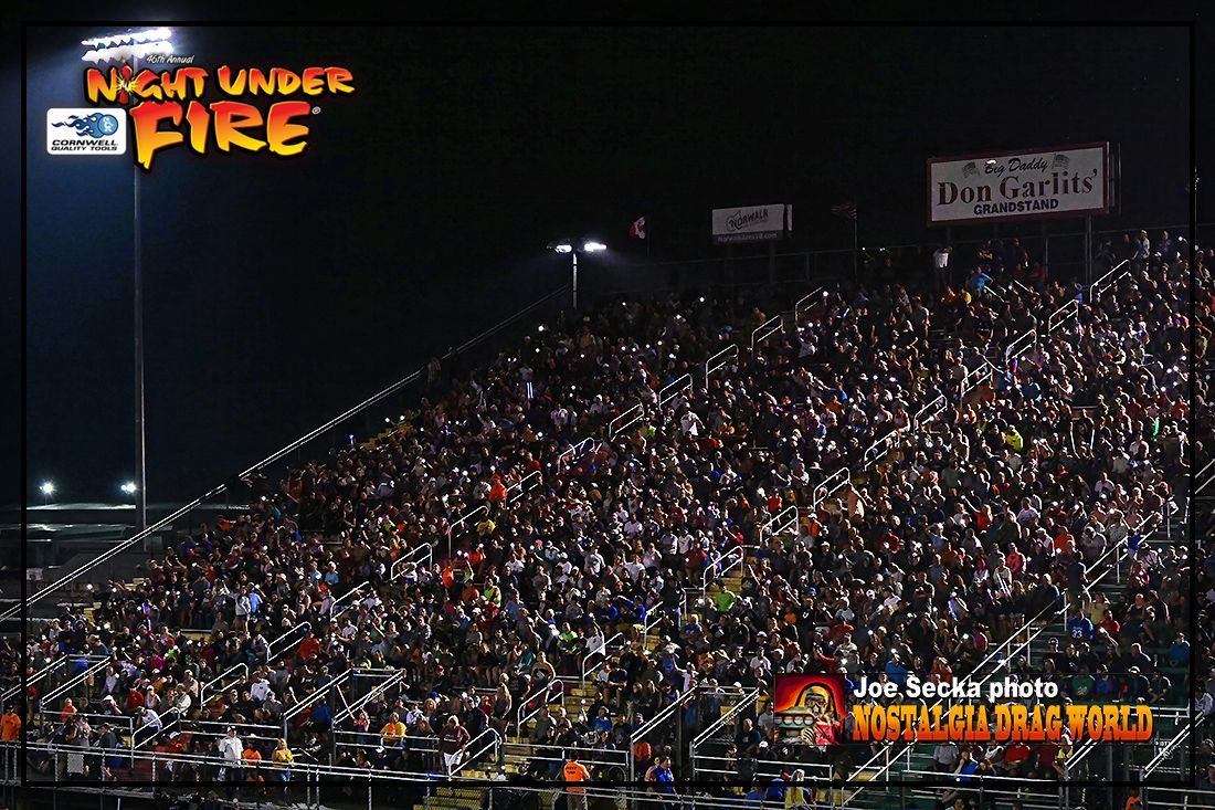 A crowd of people are watching a night under fire event