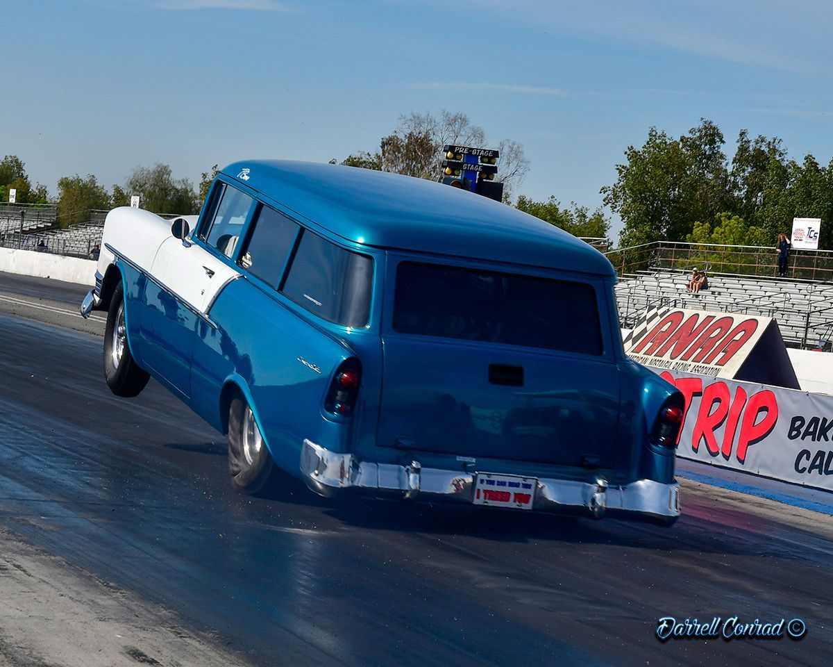 A blue and white van is driving down a race track