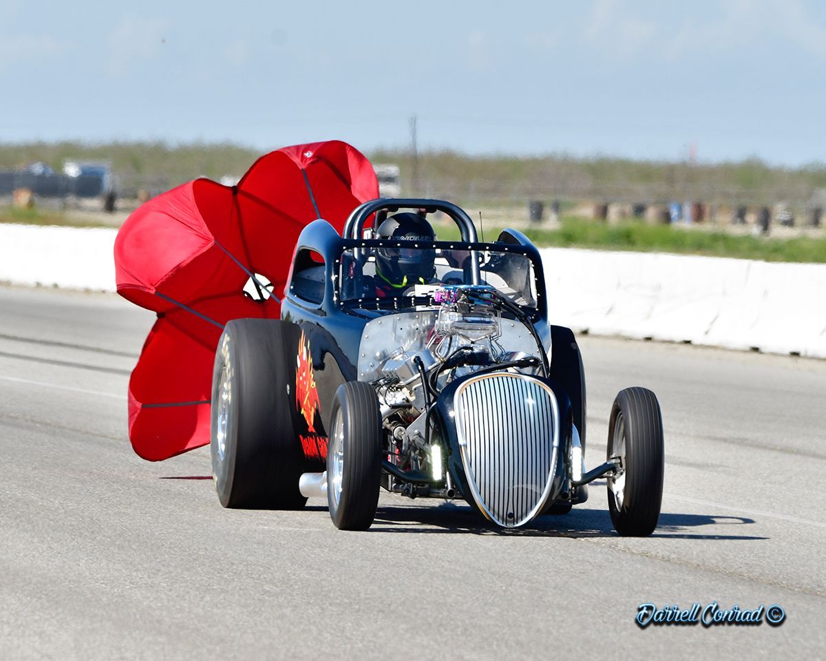 A race car with a red umbrella attached to it
