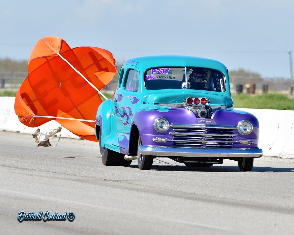 A blue and purple car with the word raven on the windshield
