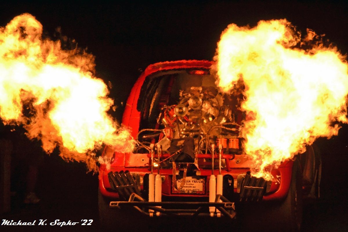 A red car with flames coming out of the engine