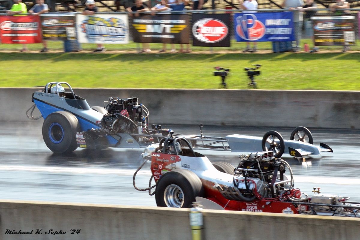 Two drag racing cars are racing on a track