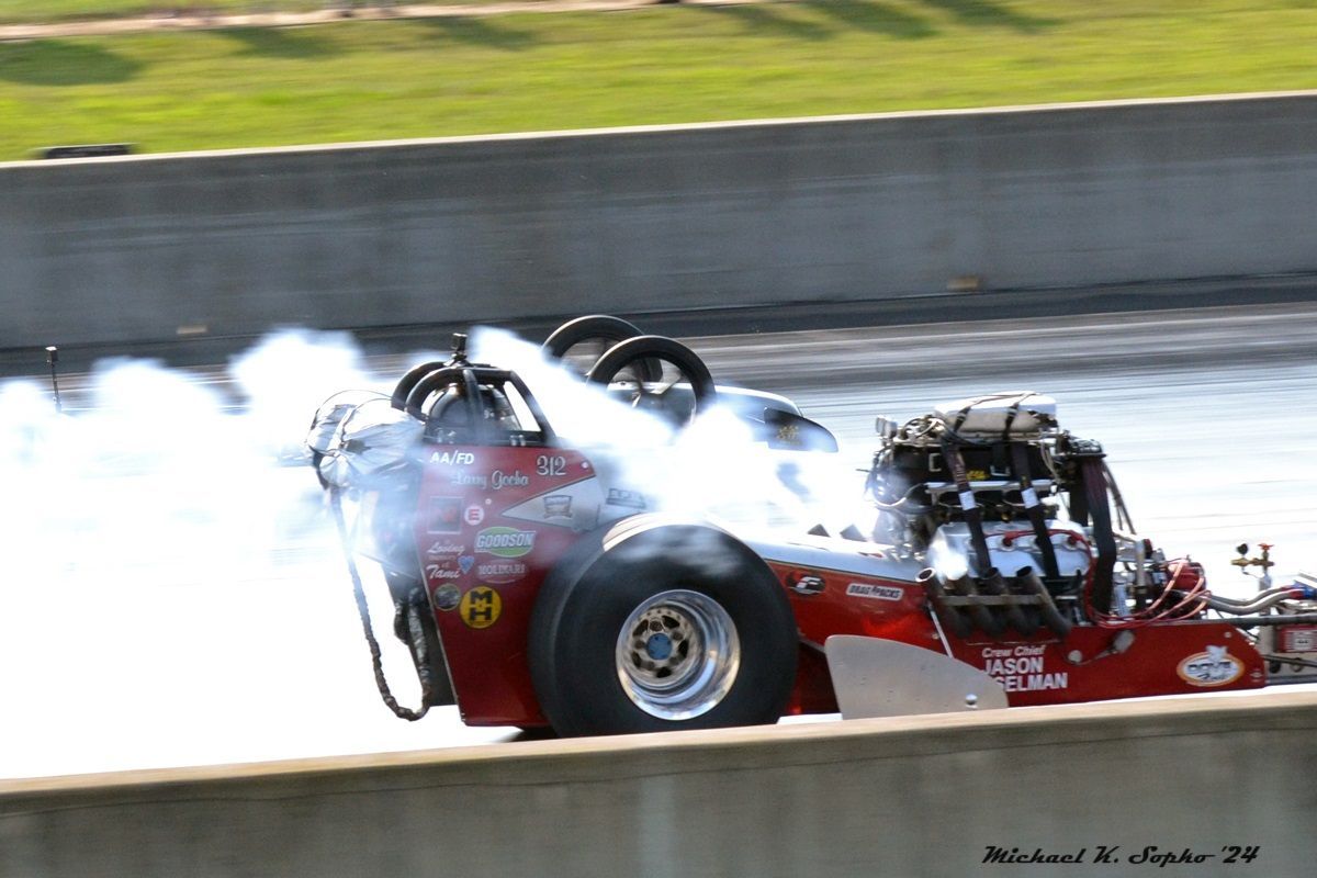A red race car with a sticker on the side that says ' coca cola '