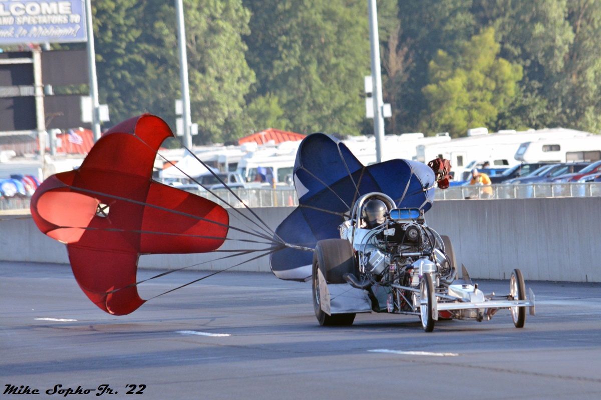 A race car with a red parachute attached to it
