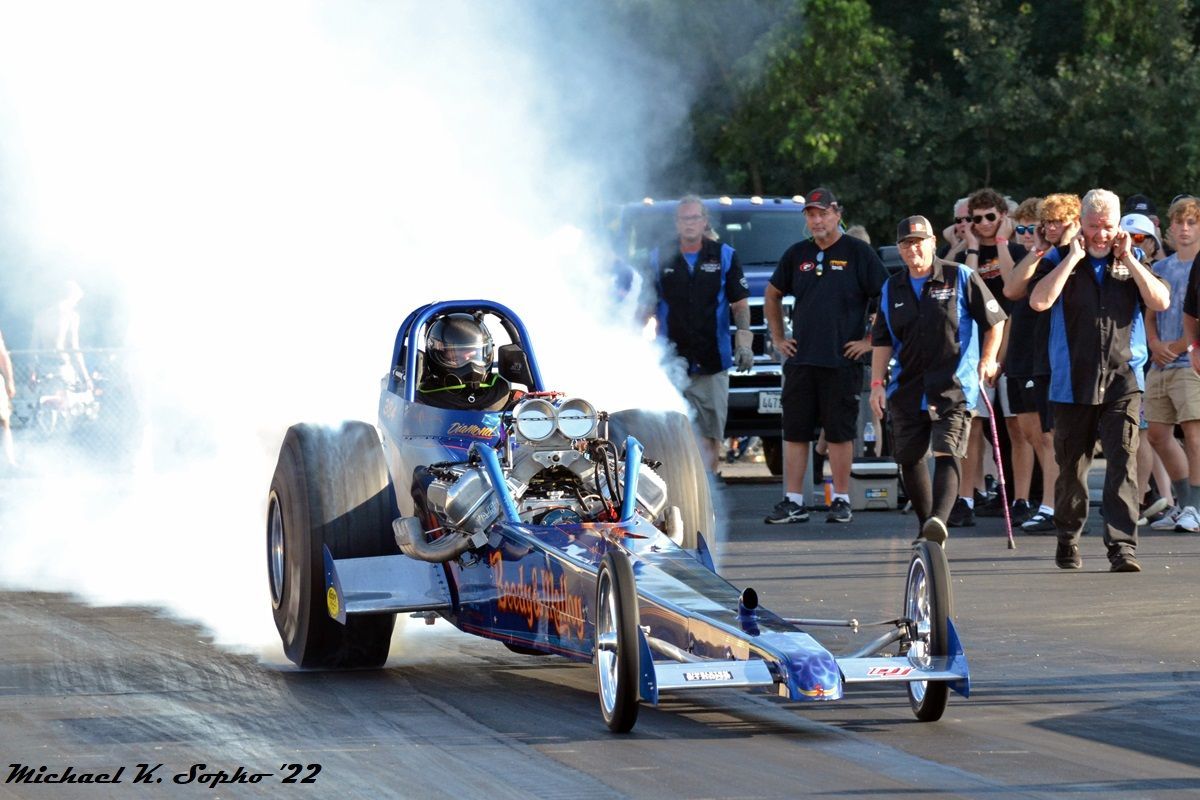 A racing car is doing a burnout with smoke coming out of it