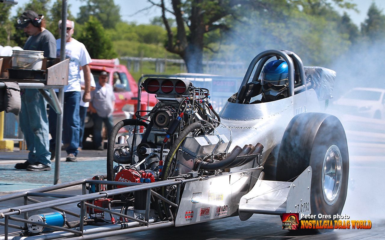 A racing car with a blue helmet on the driver 's seat
