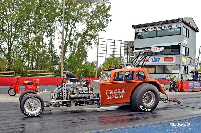 A freak show car is driving down a race track