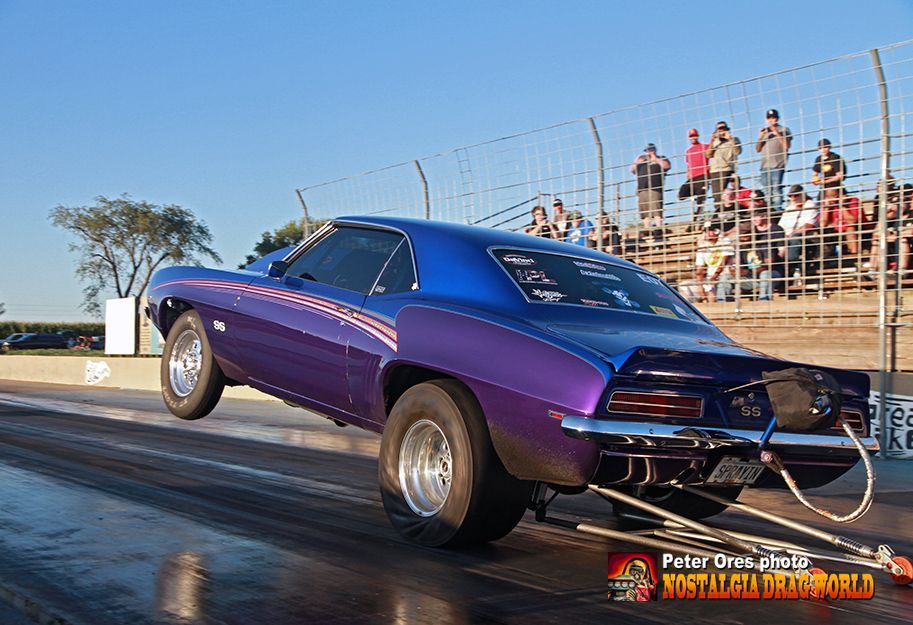 A purple car is being towed down a race track.