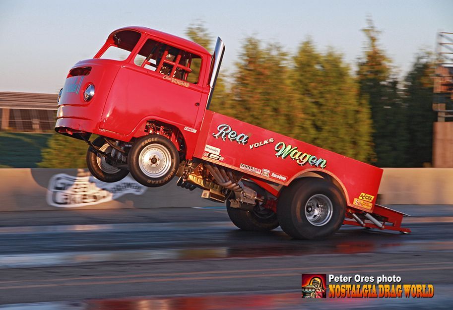 A red truck is doing a trick on a race track.