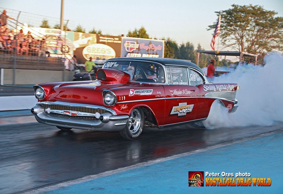 A red chevrolet is driving down a race track