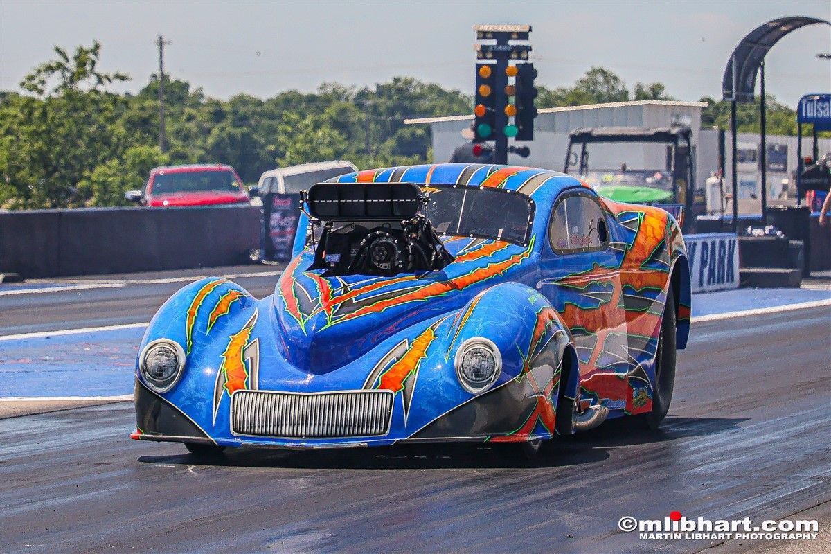 A blue and orange race car is driving down a track.