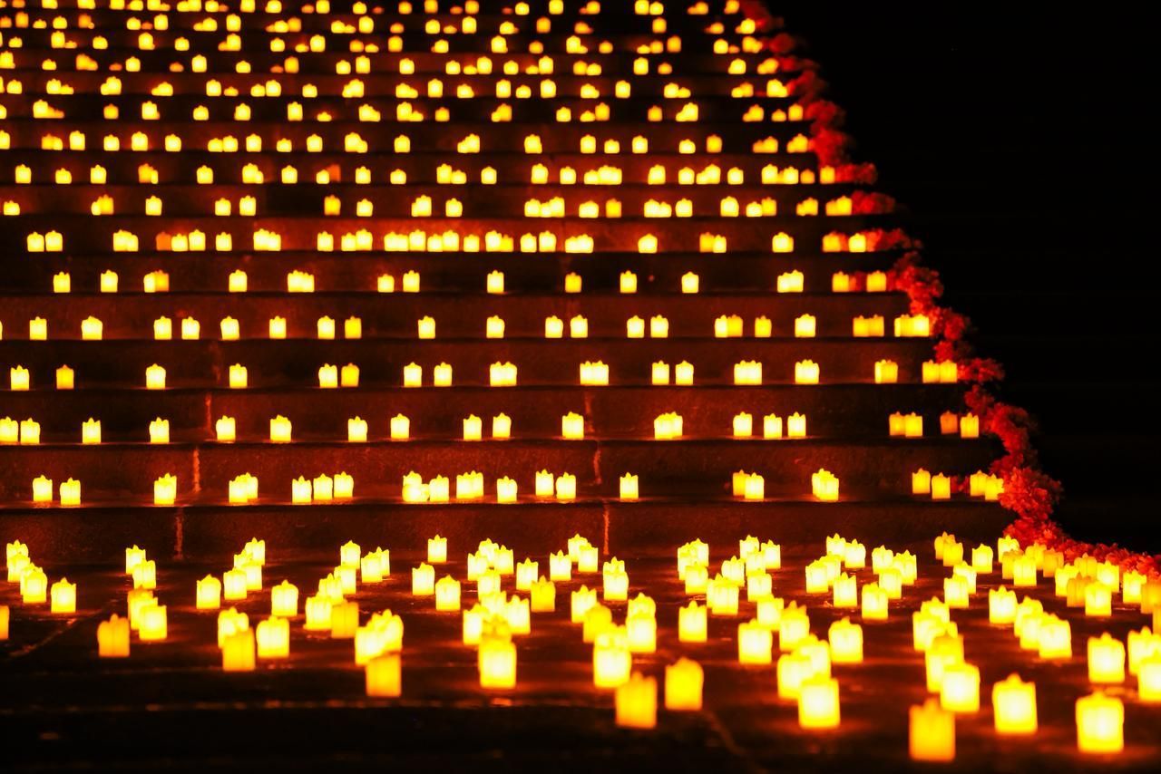 Filas de velas brillantes iluminan los escalones en la oscuridad.