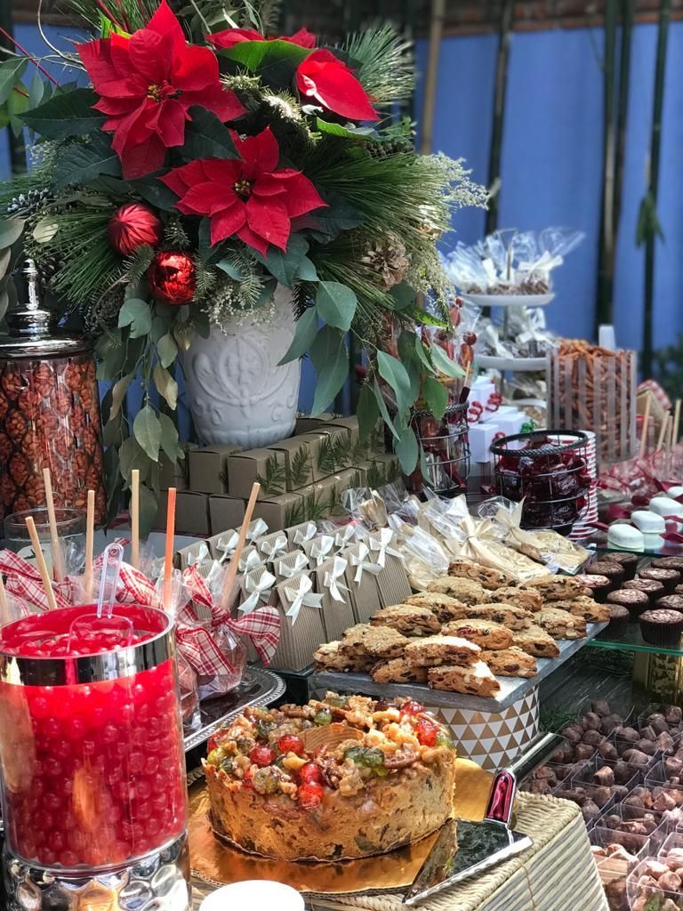 Mesa de postres festivos con flores de Pascua, galletas, dulces y pastel de frutas.