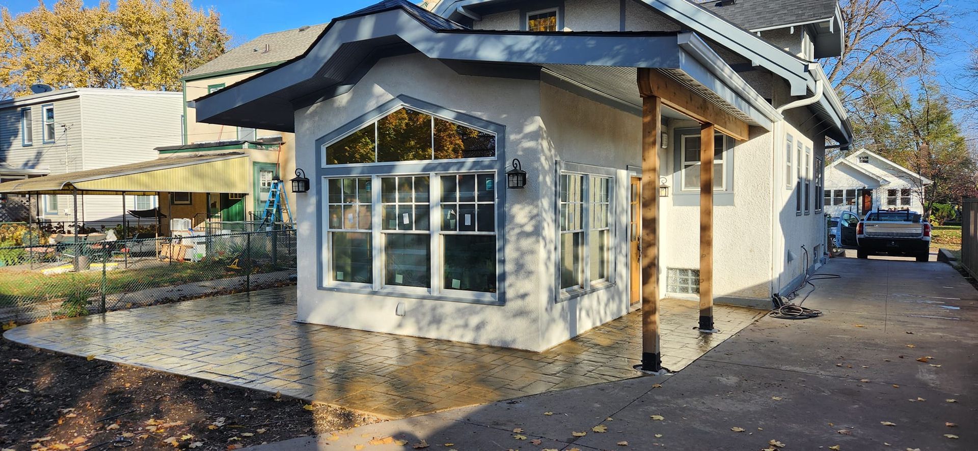 A white house with a lot of windows and a car parked in front of it.