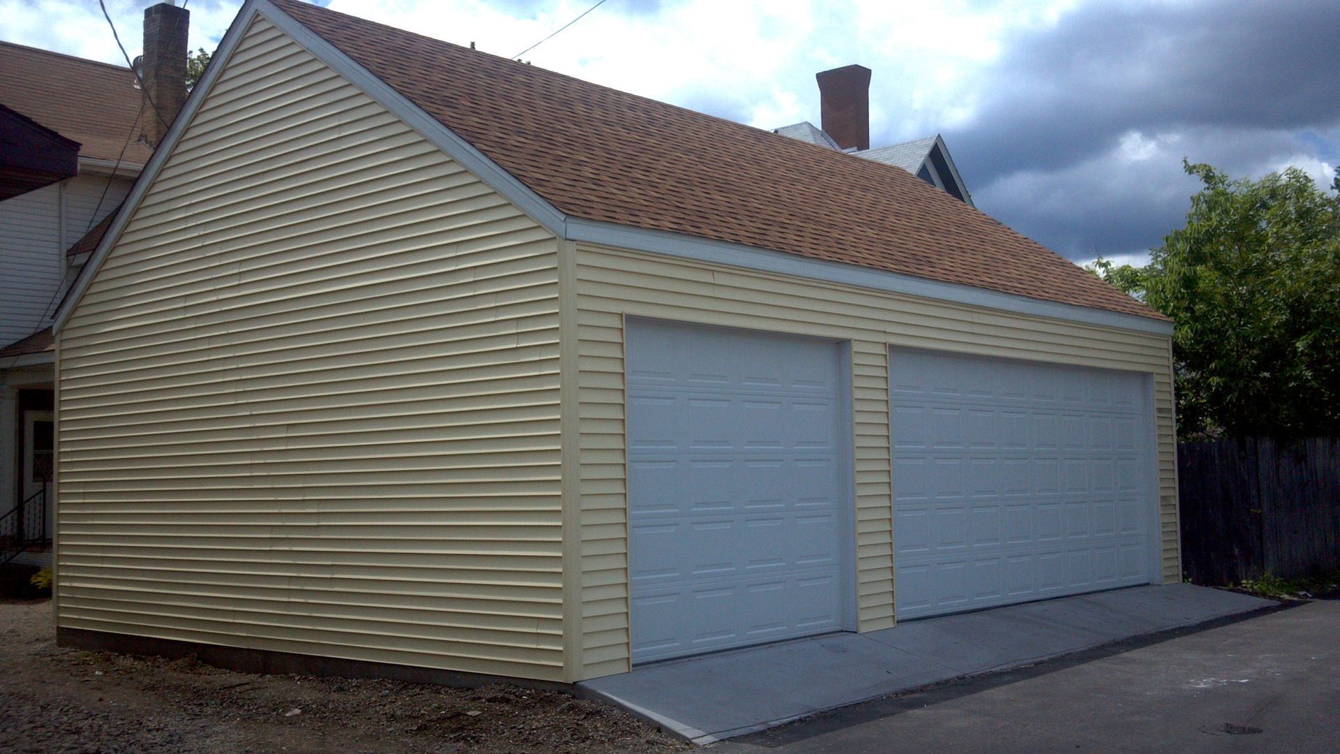 A garage with two white doors and a brown roof