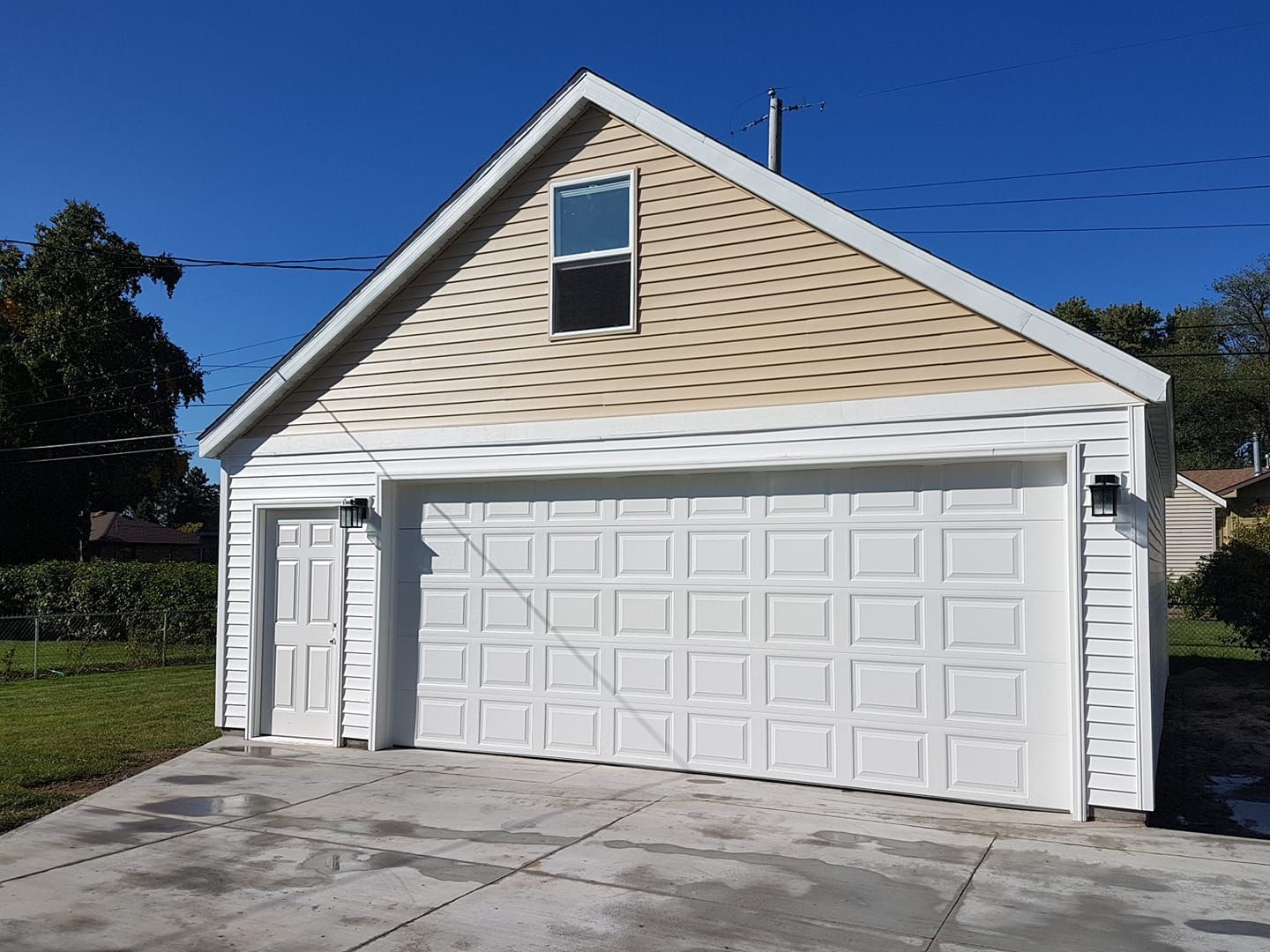 A white garage with a window on top of it.