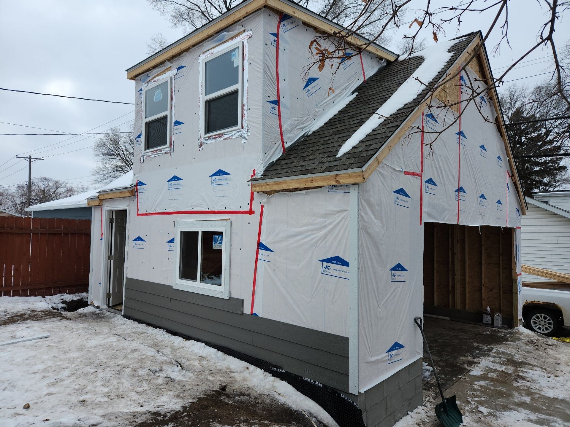 A house with a garage underneath it is being remodeled.