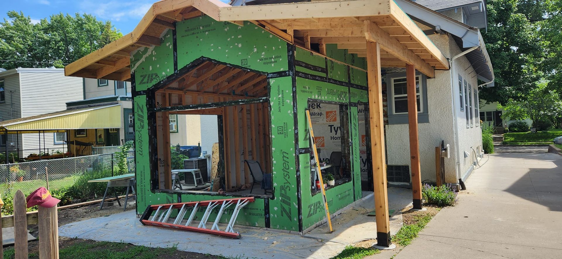 A house is being remodeled with a porch and a ladder.