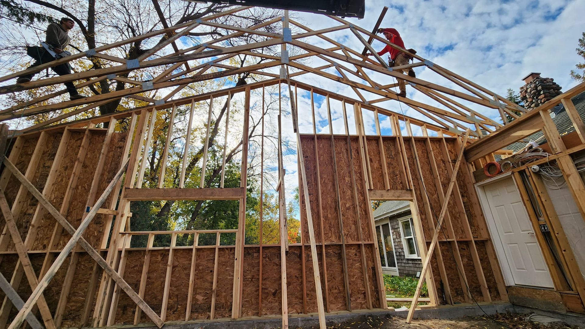 A group of people are working on the roof of a house under construction.