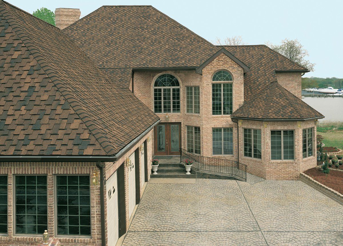 A large brick house with a brown roof