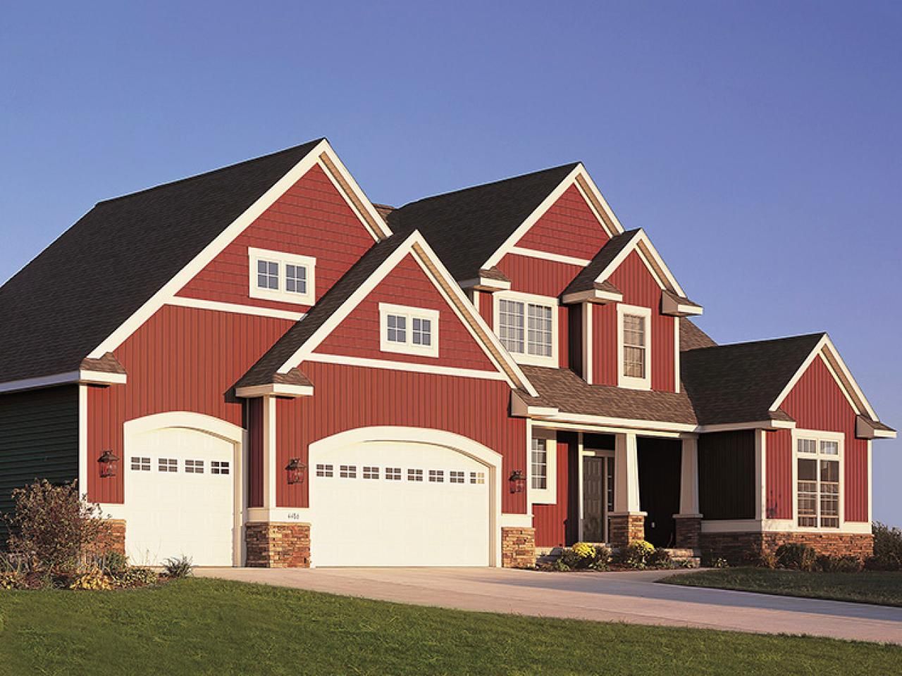 A large red house with white garage doors
