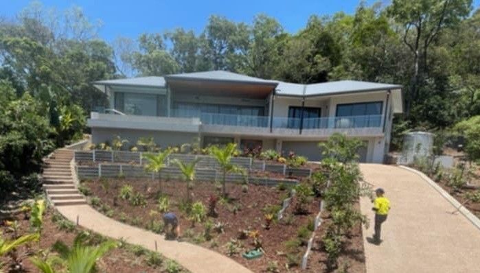 Modern house with a new concrete sleeper retaining wall, landscaped garden and exposed aggregate path installed