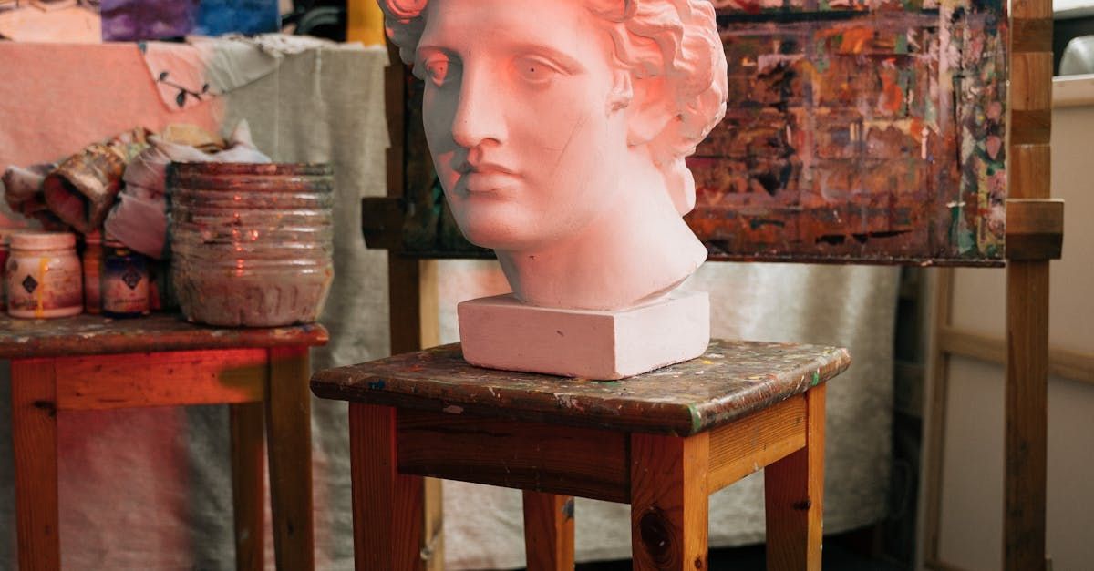 A statue of a woman 's head is sitting on a wooden stool.