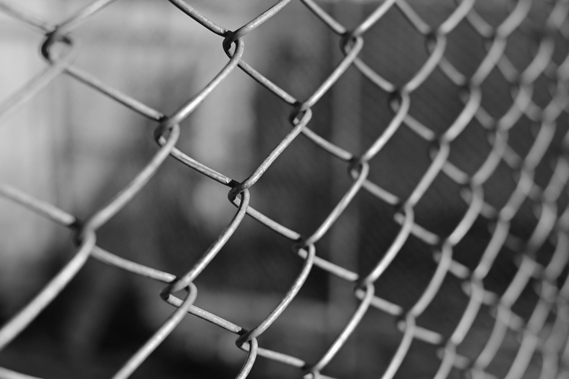 A black and white photo of a chain link fence.