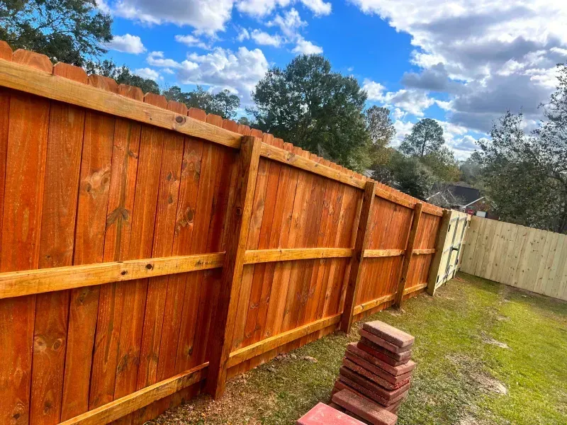 A wooden fence is sitting on top of a lush green field.